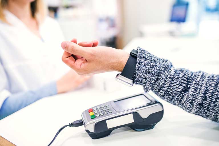 Customer making a payment with a watch via contactless payment