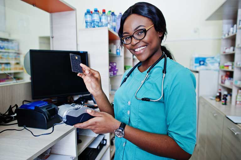 African american woman pharmacists holding a payment terminal and a credit card
